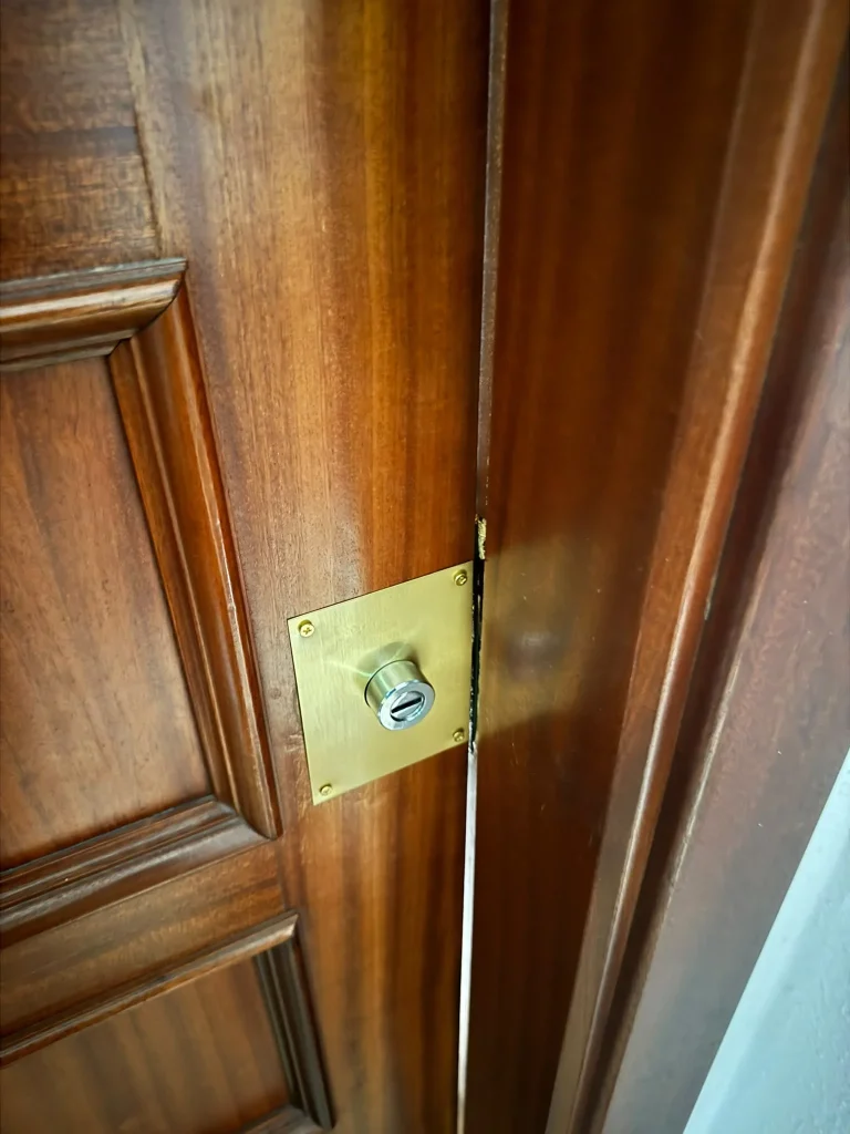 Bombín de seguridad instalado en el canto de una puerta de madera