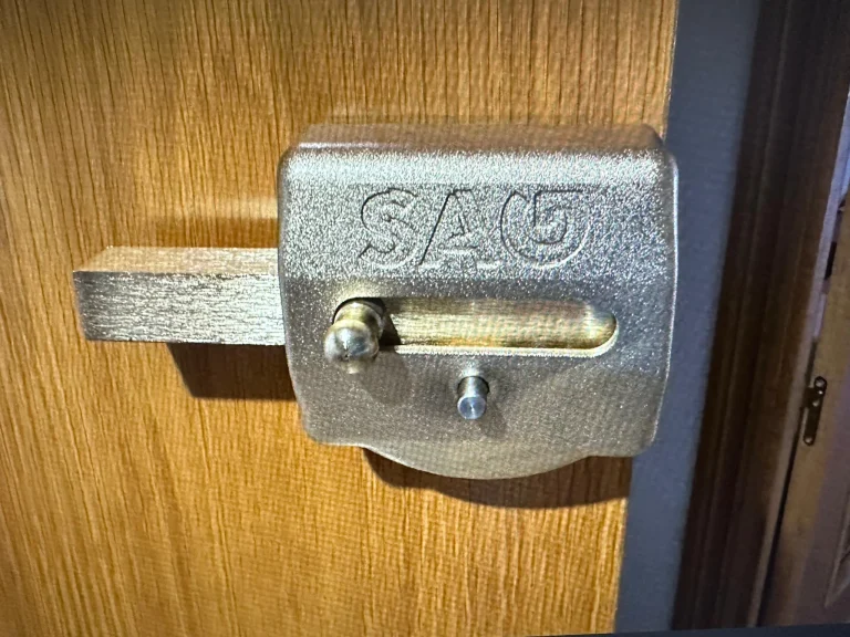 Cerrojo de seguridad de sobreponer instalado en una puerta de madera