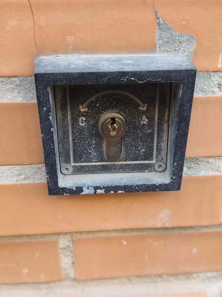 Llavín de contacto con bombín empotrado en una fachada de ladrillo